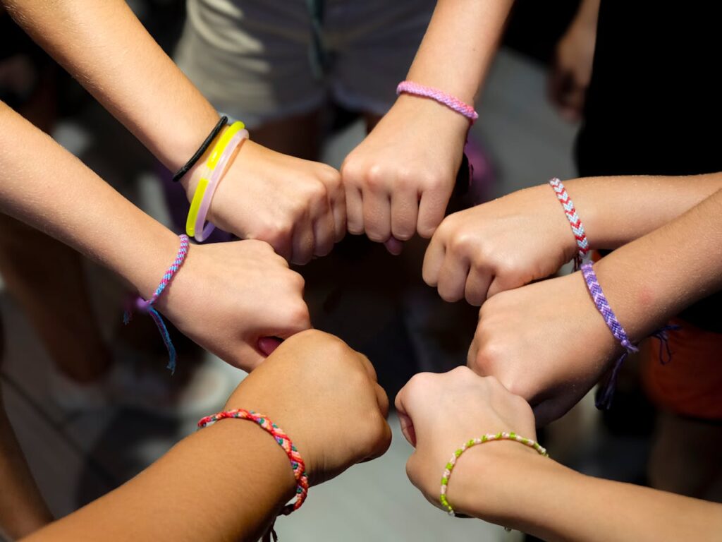 pexels-photo-34124112 A diverse group of hands wearing colorful friendship bracelets in unity.